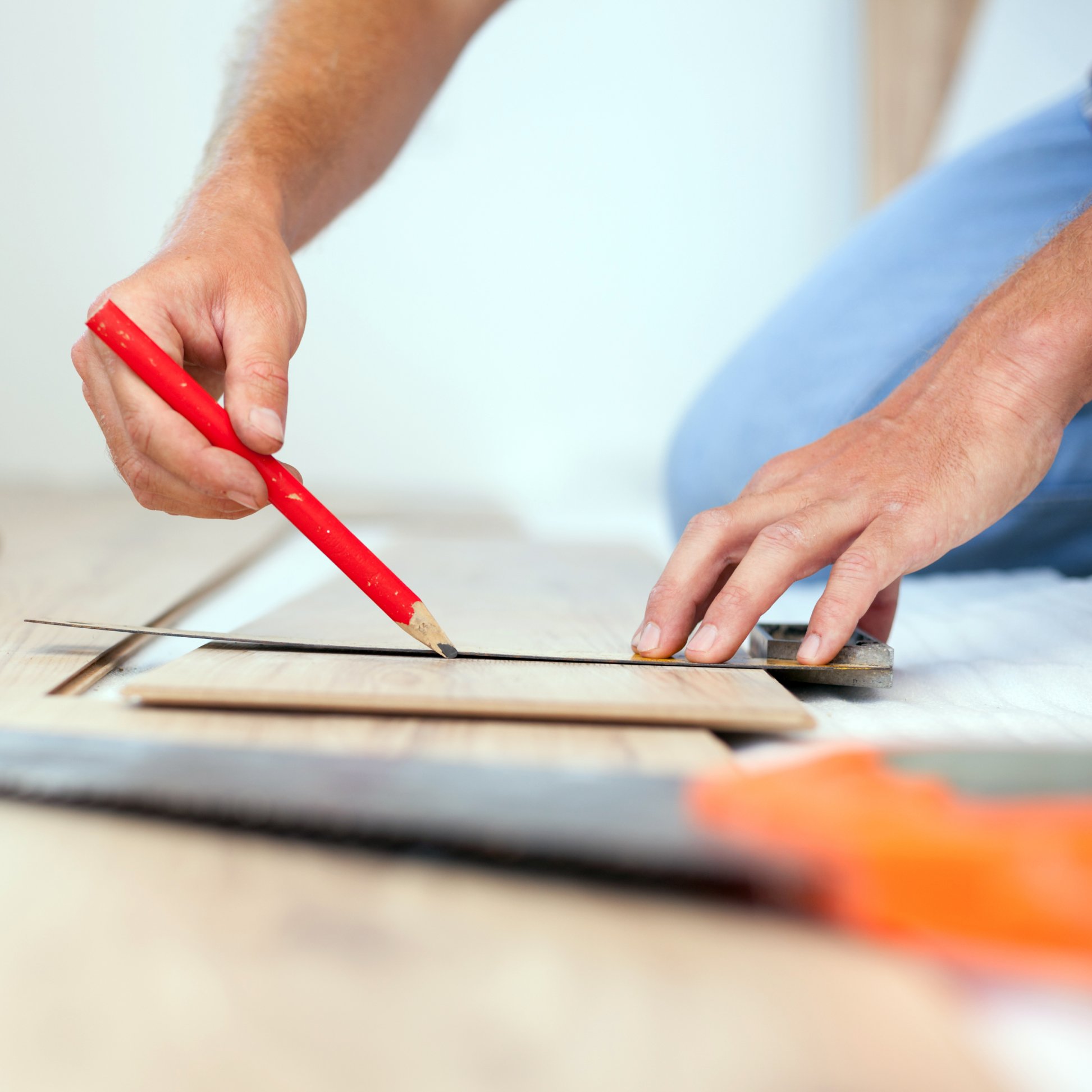 Young man measuring and marking laminate floor tile littleton co